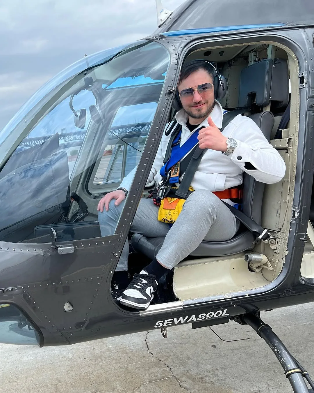 Fatih sitzt lächelnd im Helikopter und zeigt mit dem Daumen nach oben.